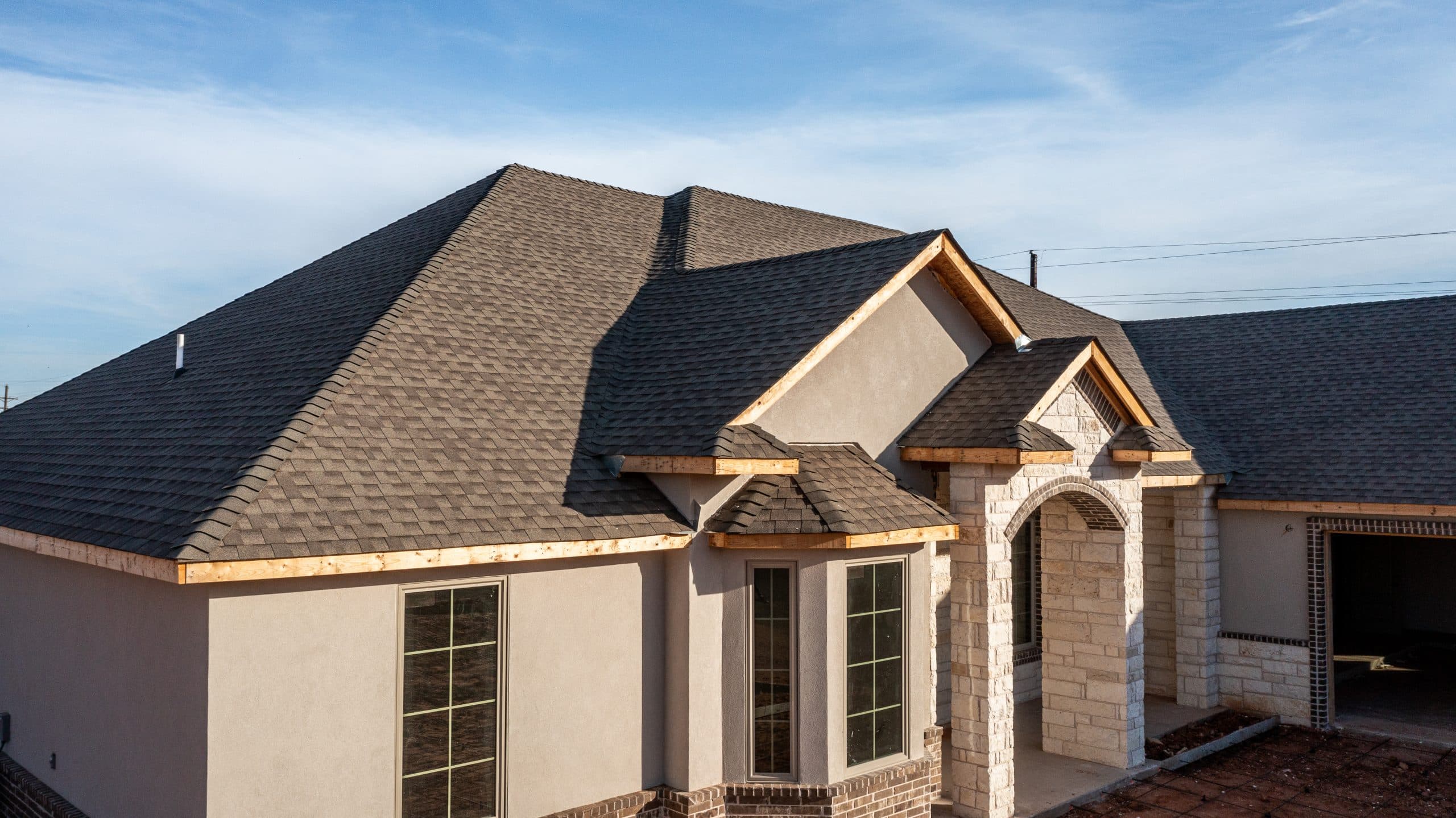 Front elevation with exposed wood along the roofline before finishing