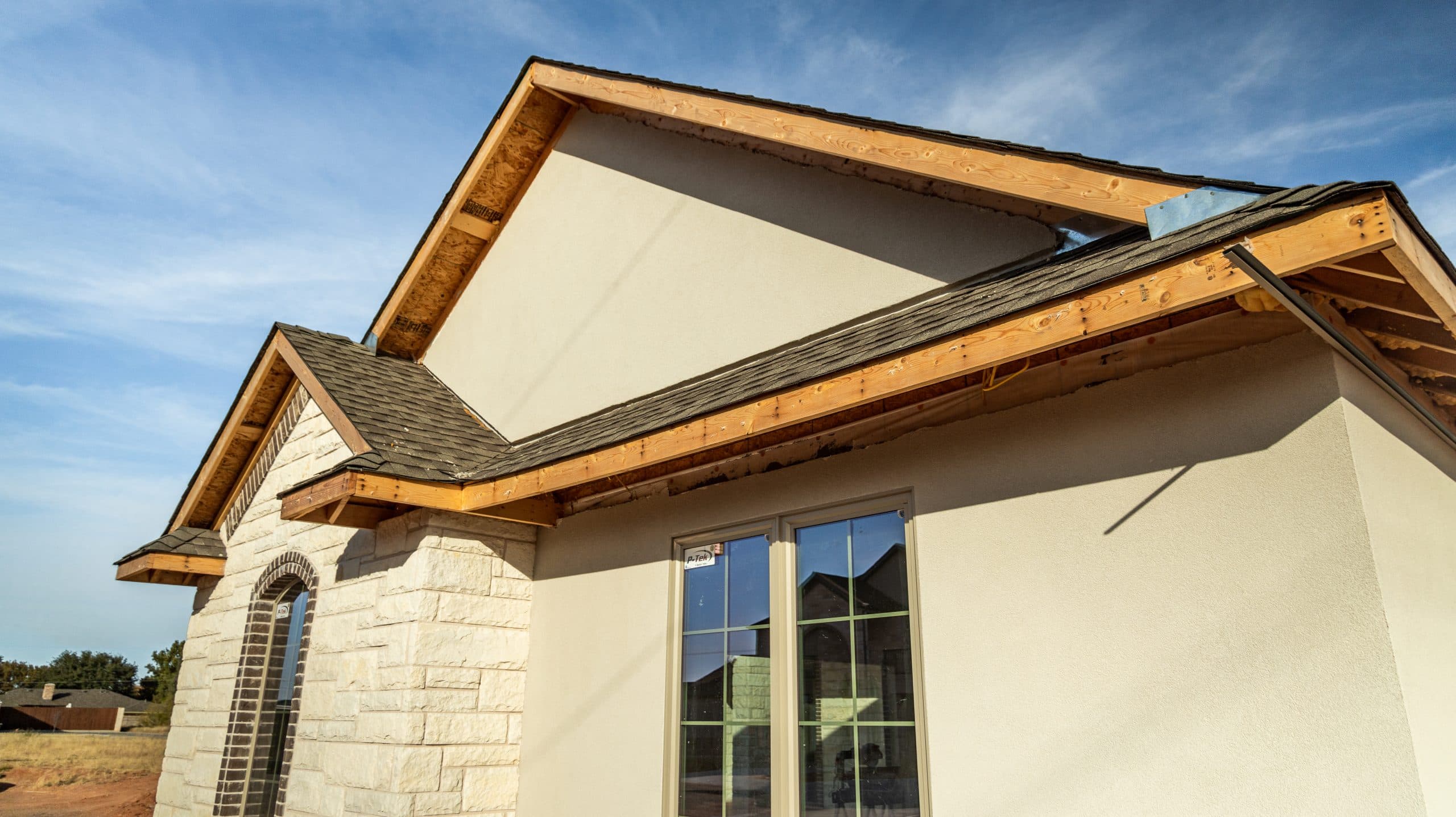 Unfinished wood fascia and open soffit along a front roofline