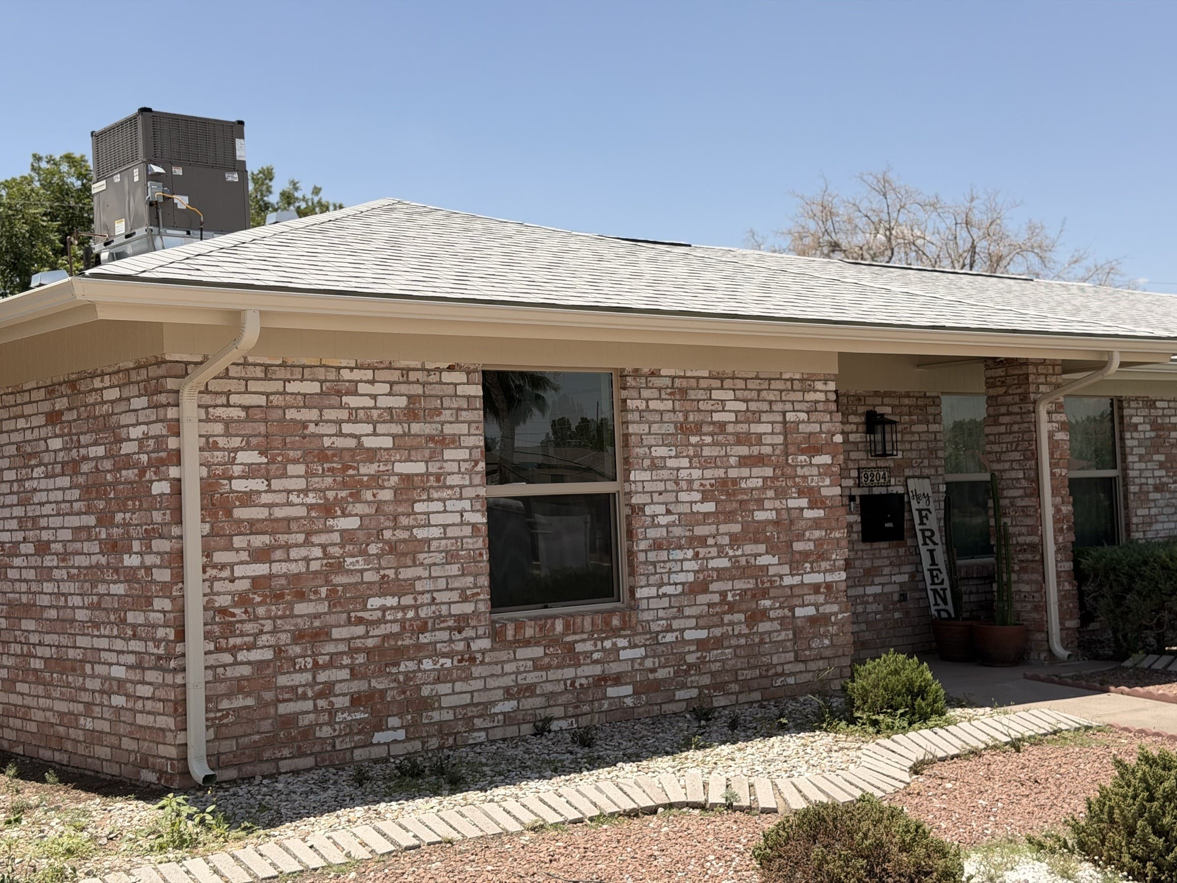 Brick home with white gutters and downspouts